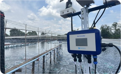 HydroNeo Mini Controller mounted on a pole beside a netted, aerated pond