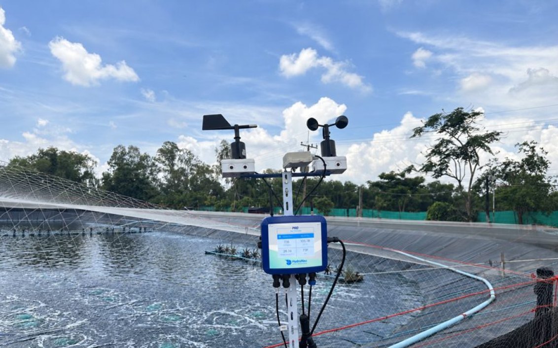 HydroNeo Mini Controller Pro mounted on a pole with wind sensors beside an aerated, lined pond