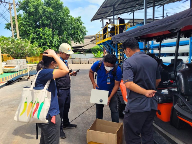 HydroNeo Team with a group of workers inspecting equipment outdoors showcasing their Mini Controller at an industrial site (Thai Union)