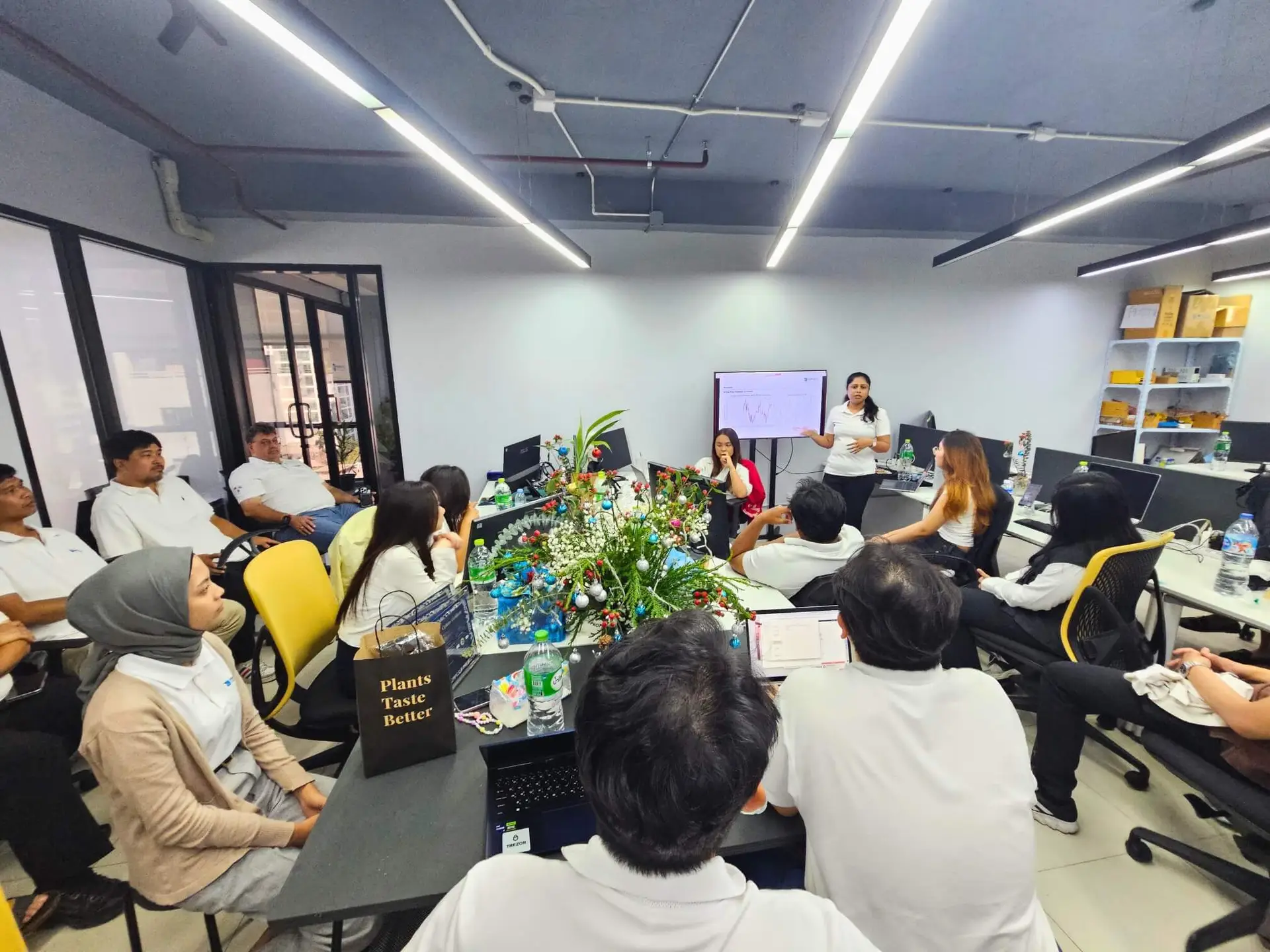 Our HydroNeo team gathered in the office, engaging in a presentation with a focus on Archana Lakshmanan, who is our speaker standing in front of a screen