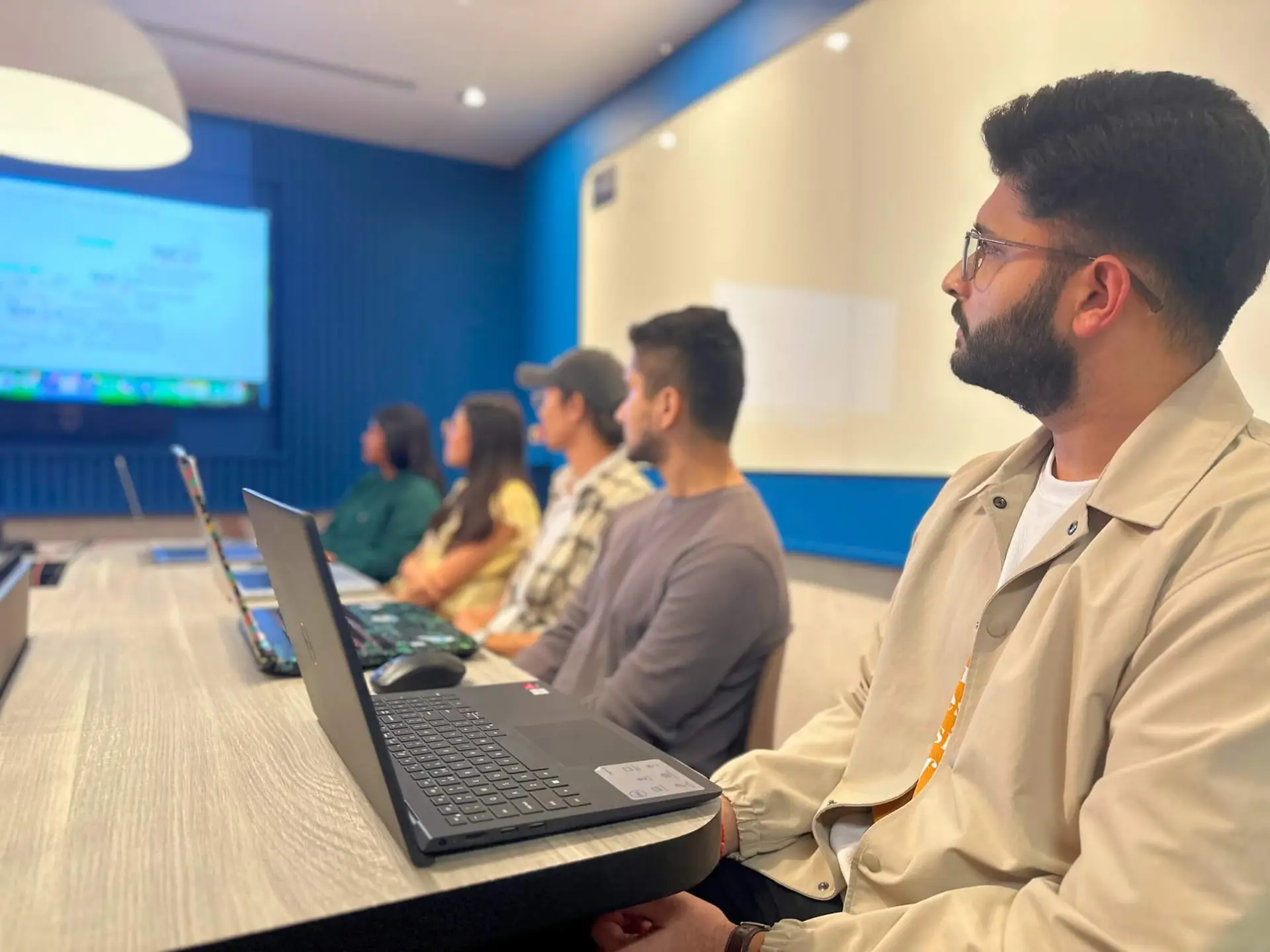 Our HydroNeo team meeting with employees listening attentively in a conference room, while a presentation is projected on the screen