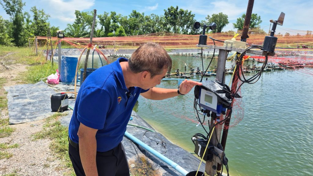 The owner of the shrimp farm is looking at the HydroNeo Mini controller screen.